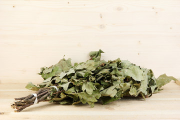 Bath broom of oak on wooden background