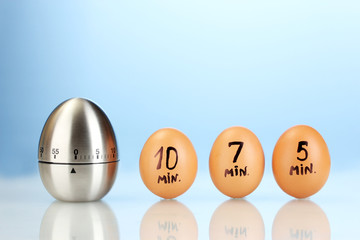 egg timer and eggs on blue background