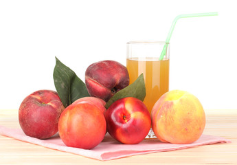 Ripe peaches and juice on wooden table on white background