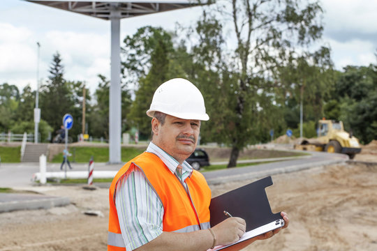 Engineer with folder near the road repair work