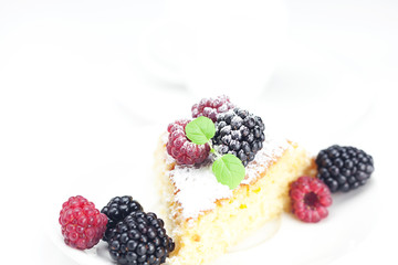cup, cake, raspberry, blackberry,nuts and mint on a plate on a w