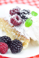 cake with icing,icecream, raspberry, blackberry and mint on a pl