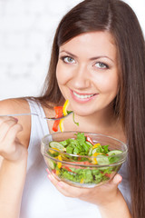 beautiful brunette woman eating salad