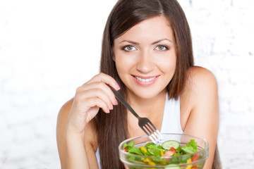 beautiful brunette woman eating salad