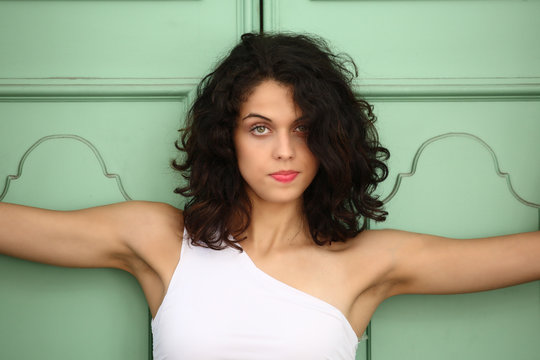 Ragazza con vestito bianco vicino alla porta verde