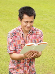 芝生の上で読書をする男性
