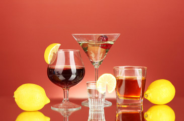 a variety of alcoholic drinks on red background