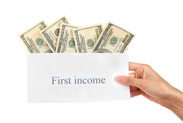 Woman's hand holding an envelope with money on white background