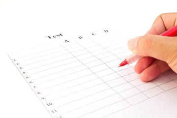 Hand on red pen choosing the test list on the examination