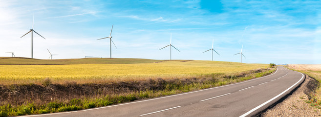 Wind turbines on summer field, green energy.