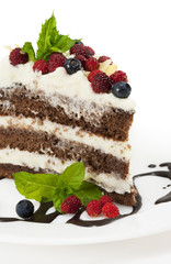 Piece of chocolate cake with chocolate glaze, whipped cream, wil