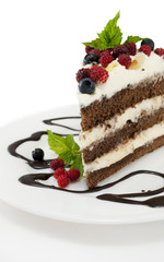 Piece of chocolate cake with chocolate glaze, whipped cream, wil