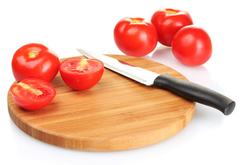 Ripe red tomatoes and knife on cutting board isolated on white