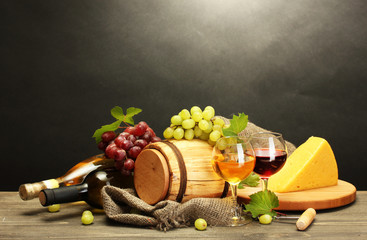 barrel, bottles and glasses of wine, cheese and ripe grapes