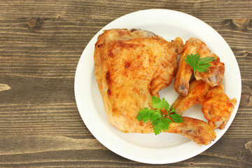 roasted chicken wings and leg with parsley in the plate