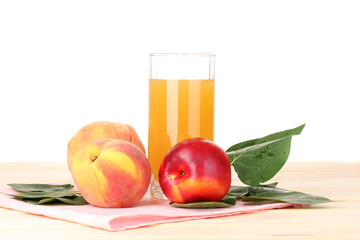 Ripe peaches and juice on wooden table on white background