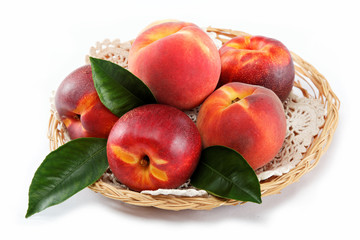 Fresh peaches and nectarines in a basket isolated on a white bac