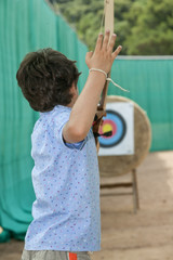 young boy makes archery