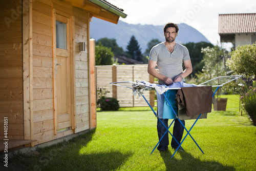 "Mann macht Hausarbeit Wäsche aufhängen im Garten" Stockfotos und