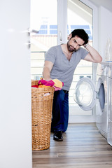 Mann ist verzweifelt bei so viel W&auml;sche f&uuml;r die Waschmaschine
