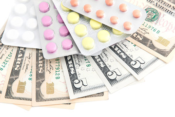 closeup pills and money concept isolated on white background