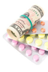 closeup pills and money concept isolated on white background
