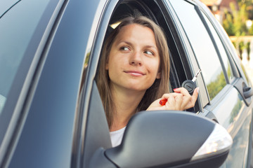 Young lady in a car showing key