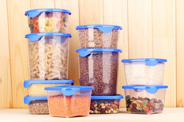 Filled plastic containers on wooden background