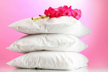Fototapeta na wymiar poduszki i kwiaty, na różowym tle