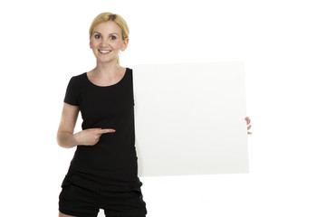 Sporliche blonde Frau zeigt auf Tafel