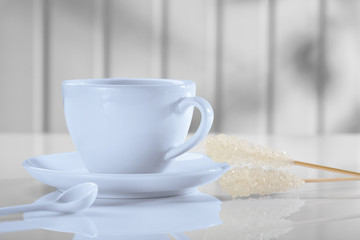 coffee cup with spoon and sugar stickon white table