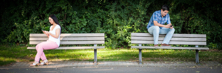 mit dem handy auf der parkbank