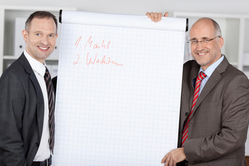 kollegen im büro stehen am flipchart