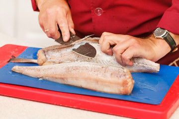 chef in restaurant slicing raw fish