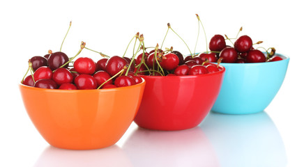 cherry in colorful bowls isolated on white