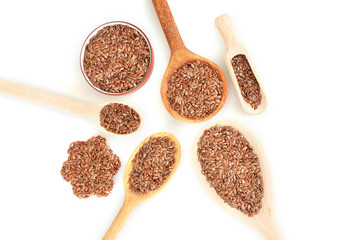 flax seeds in wooden spoons on white background close-up
