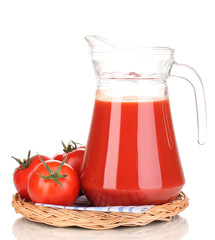 Tomato juice in pitcher on wicker mat isolated on white