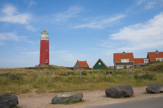 Red lighthouse, little houses and four stones on Texel island