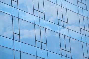 Fototapeta na wymiar Błękitne niebo i chmury, odzwierciedlając na budynku z lustrzanym szkłem