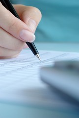 woman's hand writing entries in a notebook