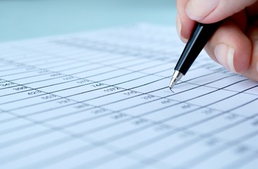 woman's hand writing entries in a notebook