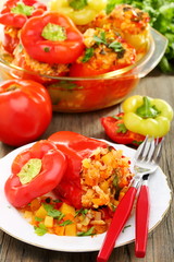 Sweet peppers stuffed with vegetables on a wooden table.