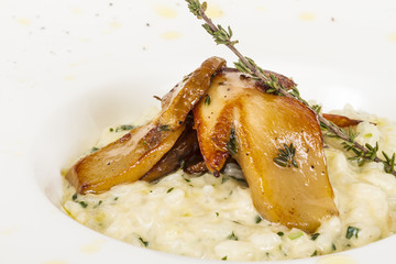 photo of delicious risotto dish with herbs and mushrooms on whit