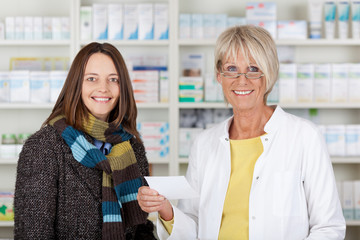 kundin mit schal kauft in der apotheke