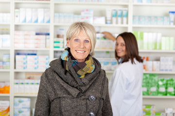 seniorin mit schal in der apotheke
