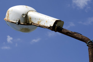 Ржавый старый уличный фонарь на фоне синего неба