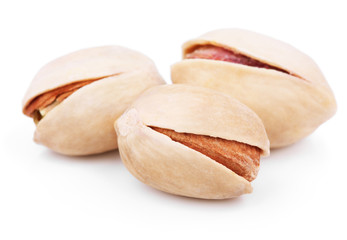 Three pistachio nuts on white