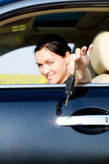 Woman handing a set of keys out of a car