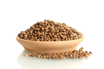 Heap coriander seeds in clay bowl isolated on white