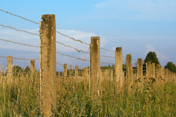 The concrete fence with barbed wire